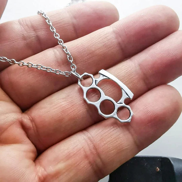 Punk brass knuckle pendant necklace with silver-tone finish, perfect for streetwear and alternative fashion lovers.